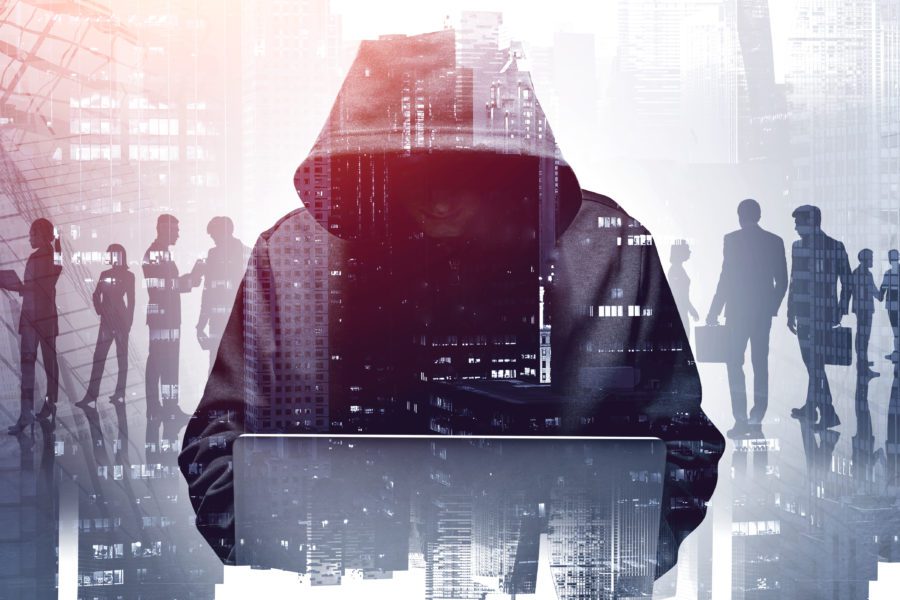 hacker in hoodie using laptop