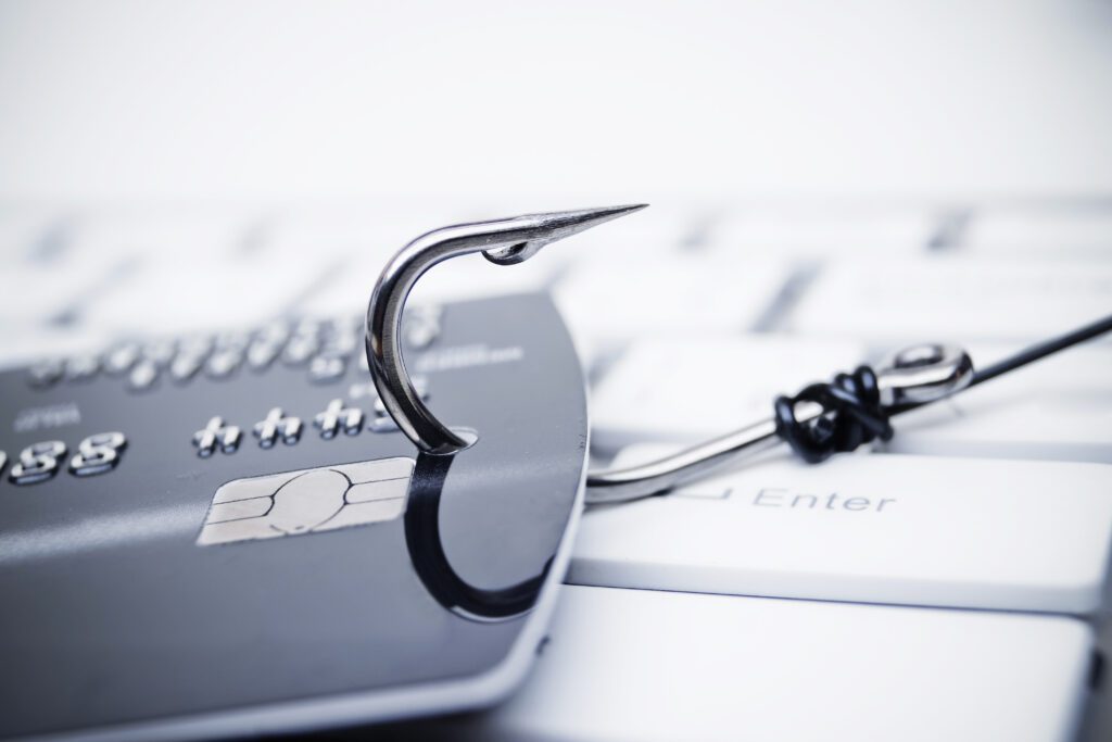 fishing hook going through credit card on top of keyboard